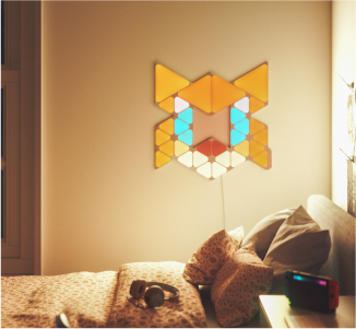 Entertainment space with Nanoleaf Shapes color changing light panels mounted on the wall behind a couch. The perfect living room lights for movie night.