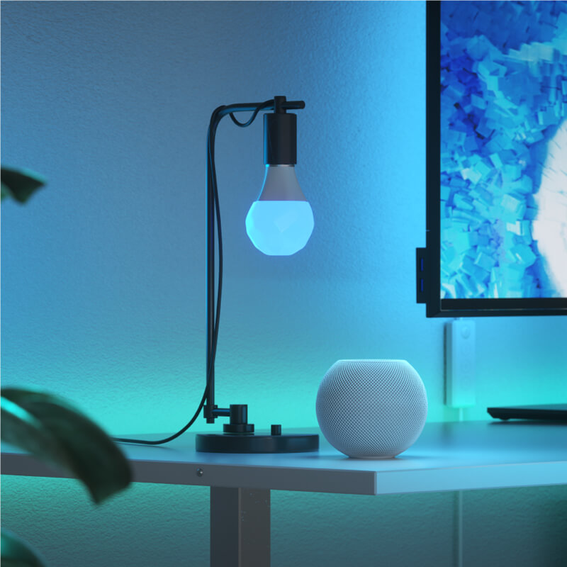 Nanoleaf Essentials Thread enabled color changing smart light bulb mounted to a fixture in a home office. Similar to Wyze. HomeKit, Google Assistant, Amazon Alexa, IFTTT.